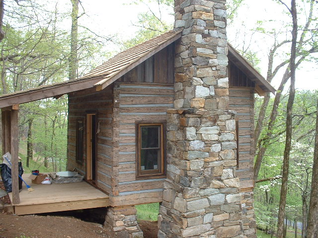 Exterior finishes: The completed cabin, with massive stone chimney. Original cabins often had large dry-stacked chimneys which were used for heat and cooking.